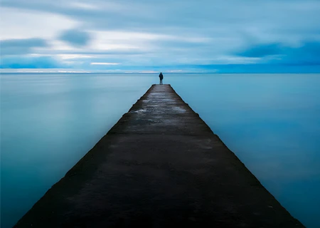 Homme contemplant la mer sur un pont